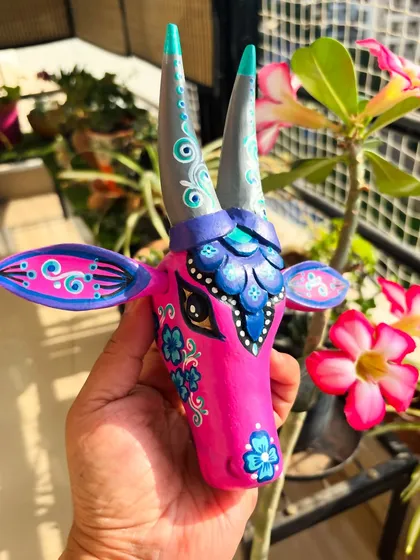 Who says traditional art can't be playful? This bubble-gum pink Nandi is a modern take on a classic form. The bright, joyful colors pop against the intricate purple and blue details, perfect for adding a splash of contemporary Indian art to your space.
