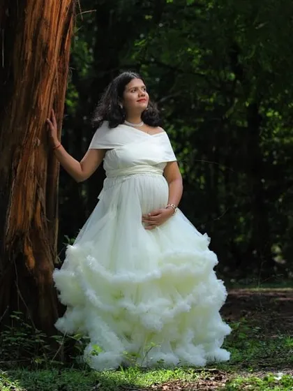 The classic white ruffled gown in a forest setting. The contrast between the elegant dress and the rustic nature creates a beautiful, timeless image.