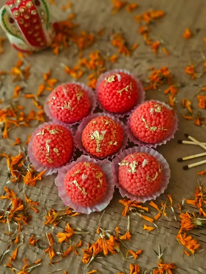 My Motichoor Ladoo candles arranged with marigold petals, creating a truly festive scene. These handcrafted candles are designed to bring a sweet glow and a lot of joy to your celebrations.