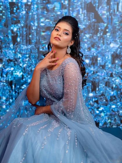 A confident pose in a stunning blue gown. The crystal-like background enhances the sparkling details of this beautiful dress.