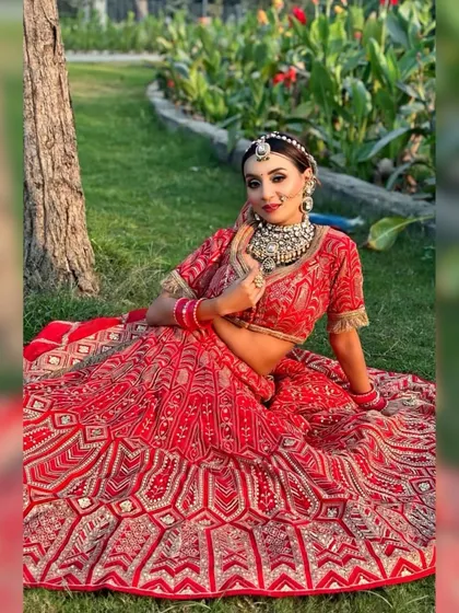 A full-length shot of the bride sitting on the grass, showcasing her entire outfit.