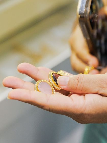 A close-up from our exclusive showcase for American Express cardmembers in Hyderabad. A client examines the intricate meenakari work on the back of a pendant.