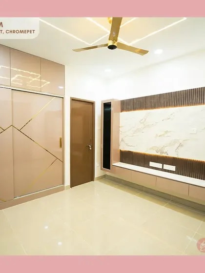 This master bedroom in our Chromepet project features a custom floor-to-ceiling sliding wardrobe with geometric gold inlays, perfectly matching the sleek, wall-mounted TV unit for a cohesive and luxurious feel.