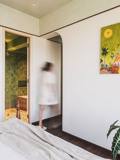 Spread across 1200-square feet, this residential space exudes tranquility with traditional details woven in seamlessly. The home is adorned with minimal details and a color palette of white, beige, grey and sage green. Natural materials such as wood, stone, and cane are used to add texture, while wallpapers with tropical imagery and traditional motifs add visual interest to the spaces.