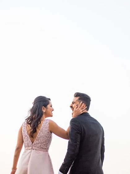 A playful, candid moment between the couple against a clean, bright sky. These minimalist shots are powerful and timeless.