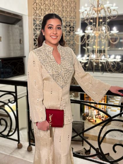 A full-length shot of Keerti's elegant Diwali look. The clean makeup allows her embroidered outfit and classic red YSL clutch to really stand out.