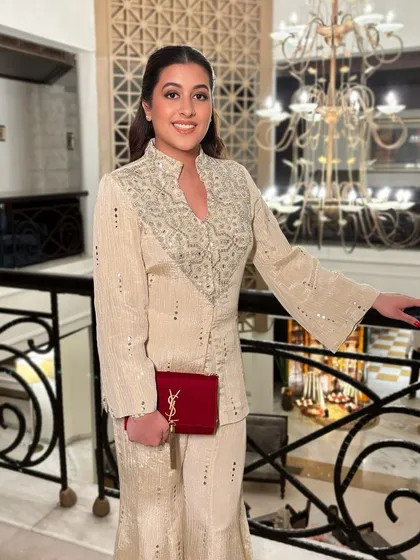 A full-length shot of Keerti's elegant Diwali look. The clean makeup allows her embroidered outfit and classic red YSL clutch to really stand out.