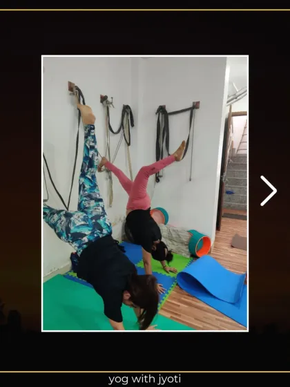 Two students practicing twisted handstands, using the wall for support to explore this advanced variation.
