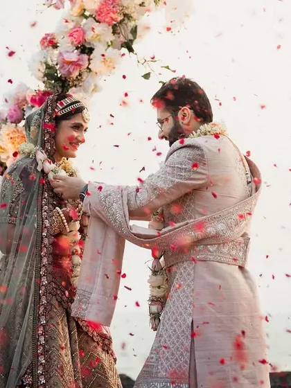 An intimate close-up of the couple exchanging garlands during their beachside Varmala. Even in a grand setting, I focus on creating space for these personal and emotional connections.