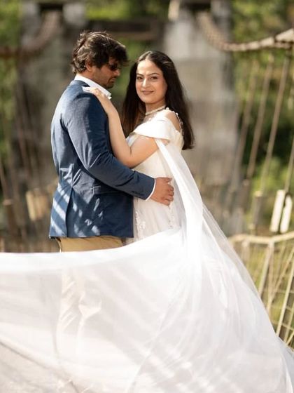 A romantic shot on a suspension bridge, with the white veil trail flowing elegantly. This gown provides endless opportunities for creative and beautiful pre-wedding photos.