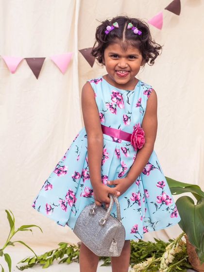 A beautiful floral print in shades of blue and pink makes this dress a cheerful choice for any day. The magenta sash adds a lovely pop of contrasting color.