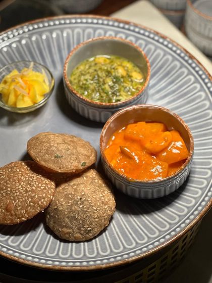 A beautifully composed plate featuring traditional Indian breads and accompaniments. The textures and colours of the food are as important as the taste.