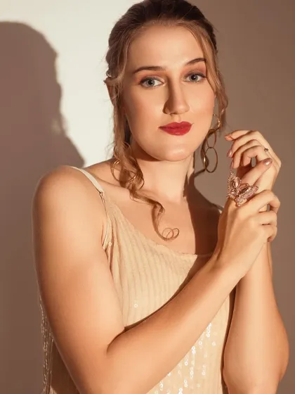 A direct and engaging portrait using the same dramatic lighting. The contrast between light and shadow highlights the model's features.