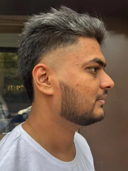 A stylish mullet haircut, showing the contrast between the short, faded sides and the longer, textured back.