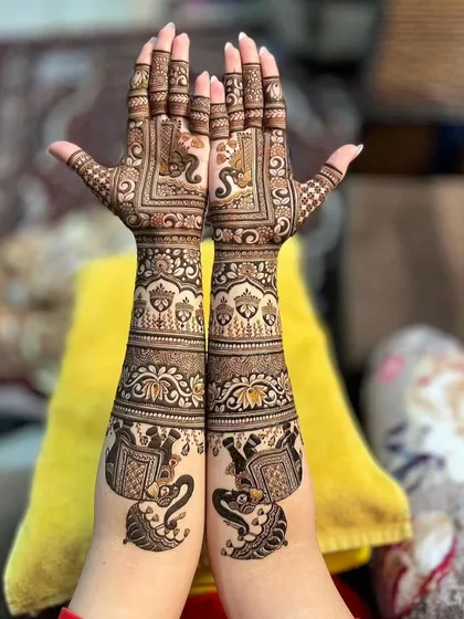 This design features striking elephant figures at the base of the arms, with their trunks raised in a gesture of welcome. The rest of the design is filled with traditional Indian motifs.