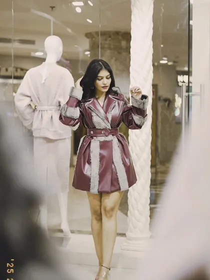 A full-length view of the burgundy trench coat. It's a powerful piece that instantly elevates any winter look.
