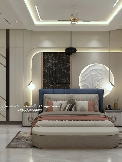 A luxurious master bedroom with a deep blue headboard and abstract wall art. The design uses a mix of textures, from the 3D rose sculpture to the dark marble panel, to create a rich and sophisticated space.