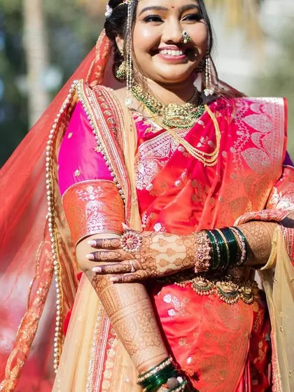 A beautiful memory from her wedding day. The bride is radiant in her red nauvari, with makeup that enhances her glow under the bright sun.