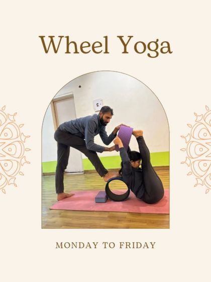 Wheel yoga is a core part of our weekly schedule. Here, a student is being assisted to achieve a deep backbend and leg stretch, demonstrating the supportive and hands-on nature of my classes.