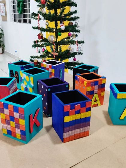 A group of personalized pen stands showing off different styles, from mosaic patterns to painted initials.