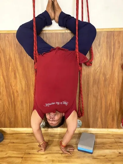Another student enjoying the benefits of a rope-assisted headstand. The ropes provide a secure way to practice inversions and improve circulation to the brain.
