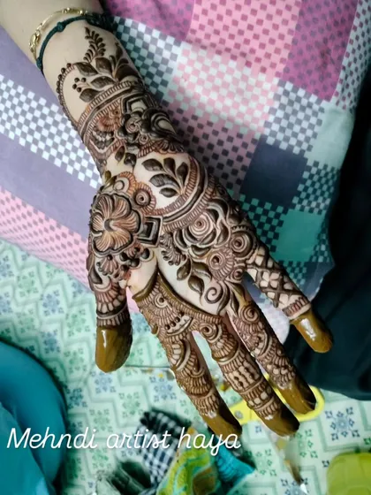 A beautiful bridal design for the palm, featuring a mix of traditional Indian motifs like paisleys and flowers.