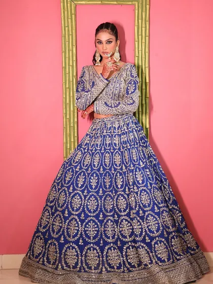 A powerful pose in the royal blue lehenga, showing its full silhouette.