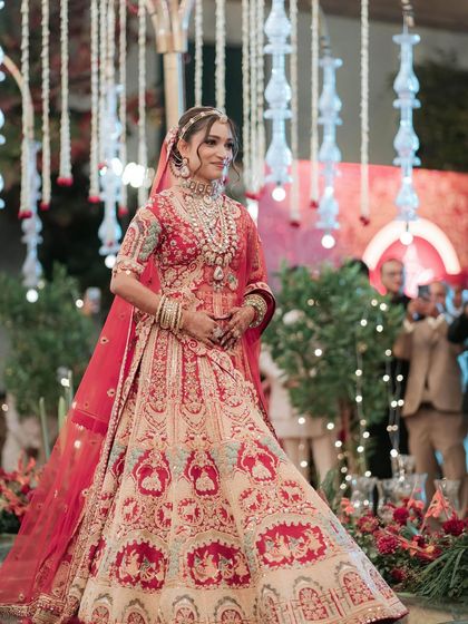 The bride makes her grand entrance. Her makeup is radiant and eye-catching, ensuring all eyes are on her.
