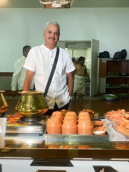 I believe in being hands-on with every event. Here I am at one of our catering stations, ensuring every detail is just right. The traditional hammered brass pots are not just for show; they are part of our commitment to serving authentic, home-style food that reminds you of a mother's cooking.