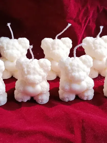 A group of the small white teddy bear candles standing together.