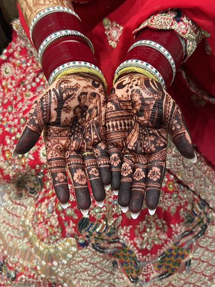 Another take on a narrative Karwa Chauth mehndi. This design includes a couple portrait and a woman looking at the moon, with intricate details filling the rest of the hands.