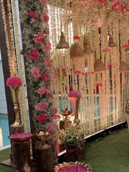 This poolside wedding decor combines rustic charm with floral elegance. We used hanging floral strings, dramatic pink arrangements, and wooden pedestals to transform the space.