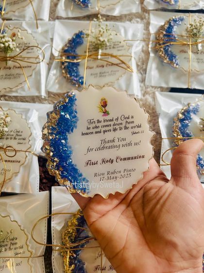 Holding one of the blue and gold communion favors. The design is both elegant and deeply meaningful.