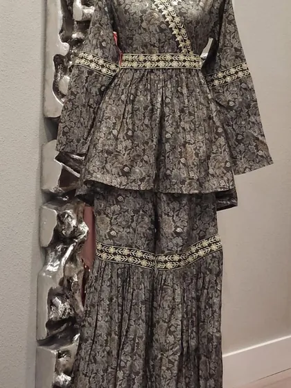 A lovely peplum-style sharara set in a subtle floral print. The angrakha-style top and tiered sharara pants make for a very flattering silhouette.