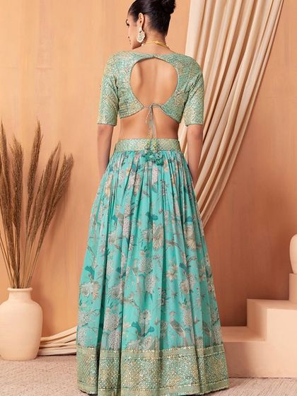 Feel like a dream in this turquoise organza lehenga. The color is so refreshing, and the sequin work adds just the right amount of sparkle for a reception or cocktail party.
