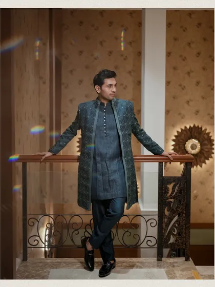 A stylish groom portrait using the architectural lines of a railing. The prism flare adds a creative touch, making this a modern and artistic shot.