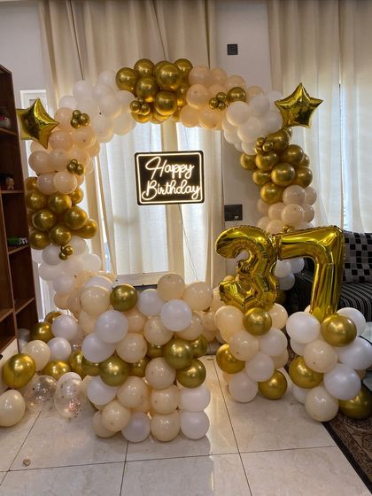 A beautiful full view of the 37th birthday balloon arch setup in a living room.