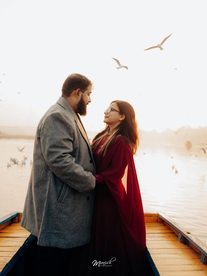 A beautiful portrait on a boat with birds flying overhead, creating a magical and serene atmosphere for their pre-wedding shoot.