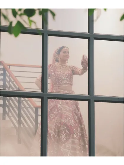 A real bride we styled completely virtually for her Montreal wedding. This dreamy shot captures her in a beautiful pink lehenga, a testament to how we can bring your entire wedding look together, no matter the distance.