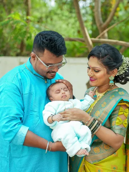 A lovely family portrait from a naming ceremony, with both parents lovingly looking at their new baby.