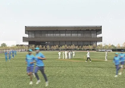 A view of the Sports Block from the cricket practice grounds. The building is designed to be a backdrop for the athletic activity, with large openings and viewing terraces.