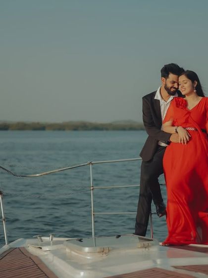 An intimate embrace on the deck of a yacht. The flowing red gown adds a touch of romance and passion to this beautiful pre-wedding moment.
