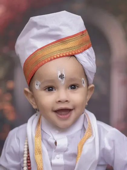 A heart-melting close-up of a baby Varkari with a huge smile. This shot captures the pure joy and innocence of childhood, enhanced by the traditional tilak and turban.