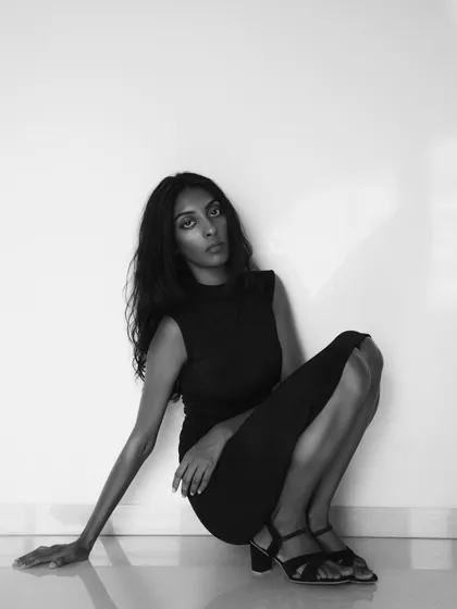 A simple, elegant portrait in black and white. The clean lines, the model's direct gaze, and the minimalist setting result in a timeless and sophisticated image.