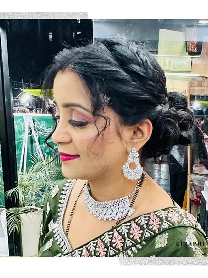 A side view of this party-ready client, showing off her beautiful braided updo and sparkling jewelry.