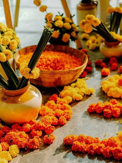 A beautiful arrangement of orange and yellow marigolds on the floor, ready for the Haldi rituals. We use flowers to create artful and meaningful arrangements.