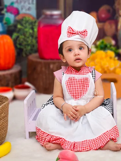 Posing perfectly in her chef's outfit. This portrait showcases the adorable details of the costume and the colorful, food-filled set.