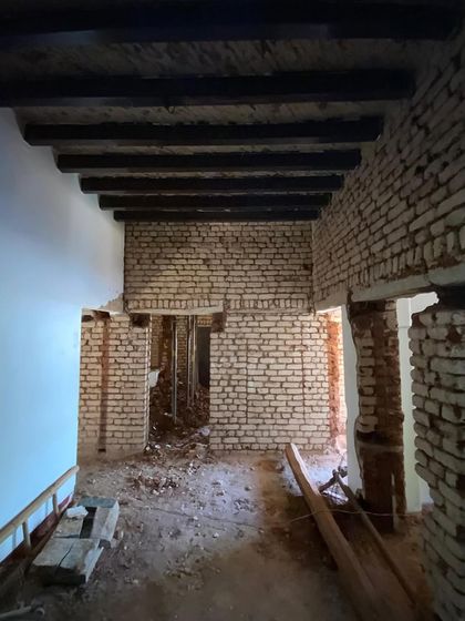 The interior of the old villa, stripped back to its essential structure. You can see the original timber ceiling beams and exposed brick, which we are carefully integrating into the new design.
