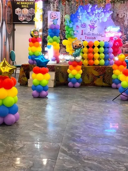 A complete view of the Cocomelon themed banquet hall decoration, with sofas for guest seating and colorful balloon pillars creating a festive party zone.