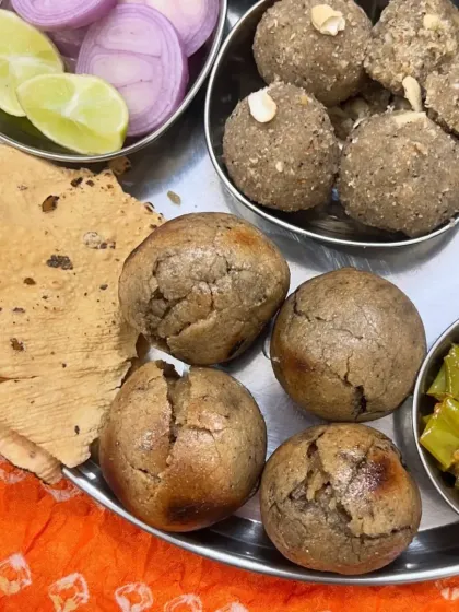A close-up of a traditional Rajasthani thali featuring Dal Bati and Churma Ladoo, a complete and satisfying meal.
